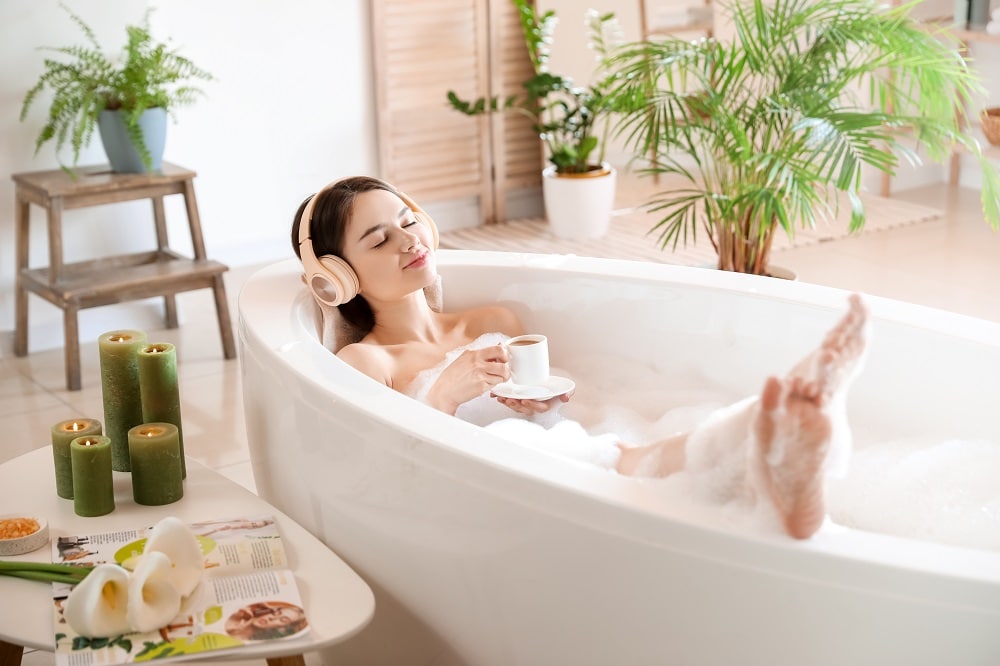 Young,Woman,With,Headphones,And,Cup,Of,Coffee,Taking,Bath