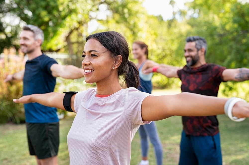 Group,Of,Multiethnic,Mature,People,Stretching,Arms,Outdoor.,Middle,Aged