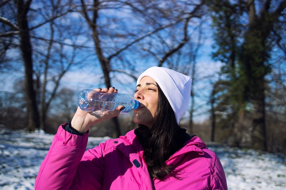 Female,Athlete,In,Winter,Clothes,Drinking,Water,Before,Training,On