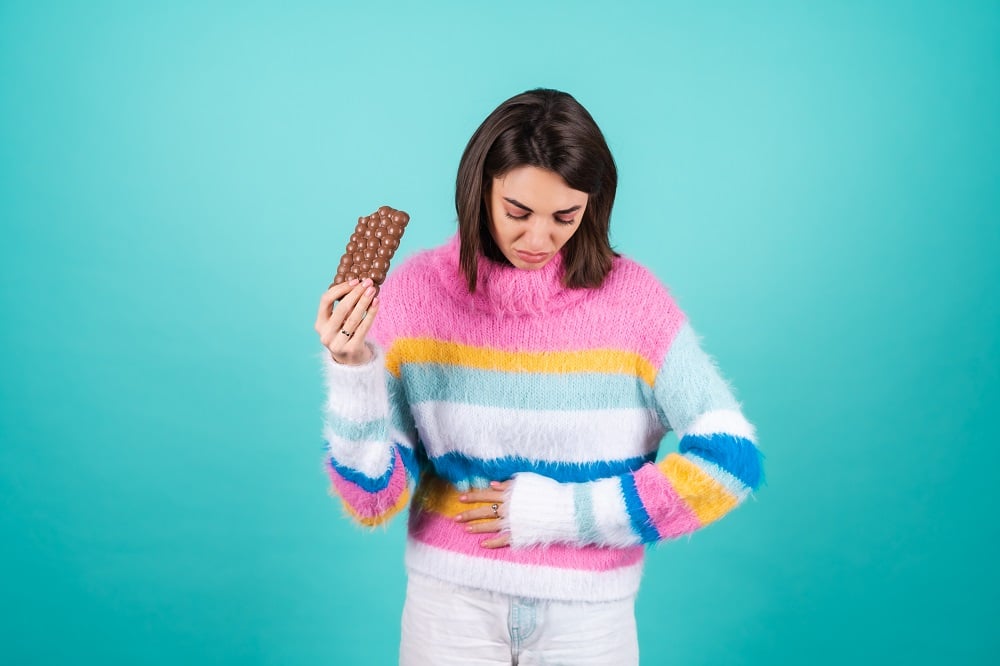 Young,Woman,In,A,Bright,Multicolored,Sweater,On,A,Blue