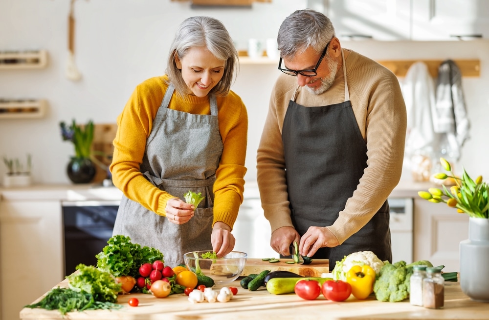 Happy,Elderly,Couple,Smiling,Husband,And,Wife,In,Aprons,Prepare