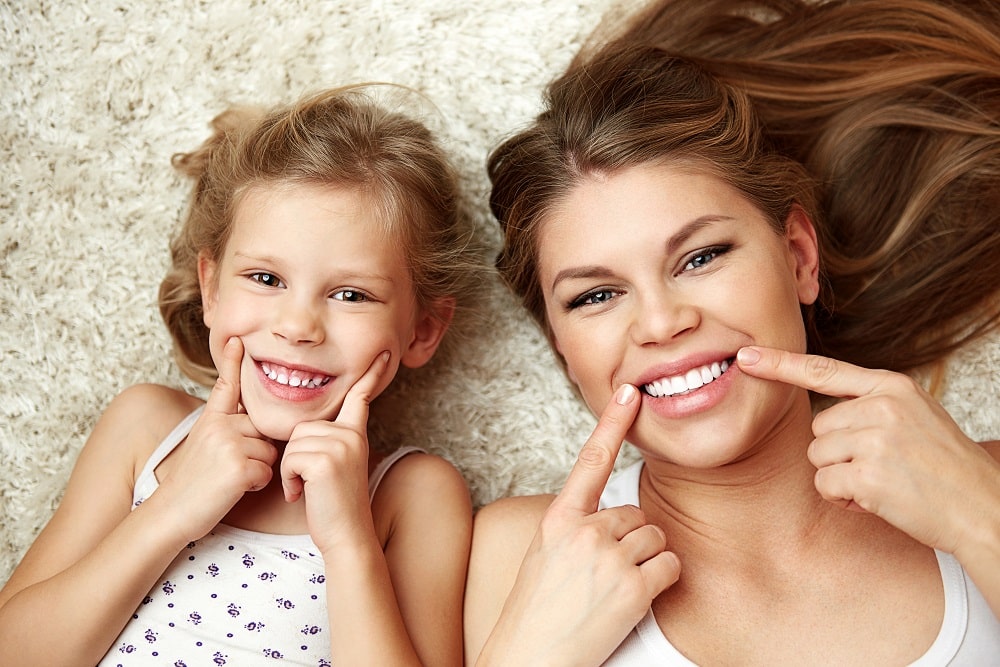 woman and daughter smiling after the dentist