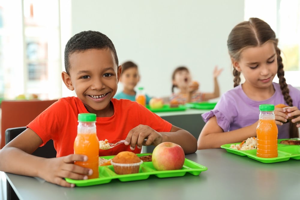 Children,Sitting,At,Table,And,Eating,Healthy,Food,During,Break