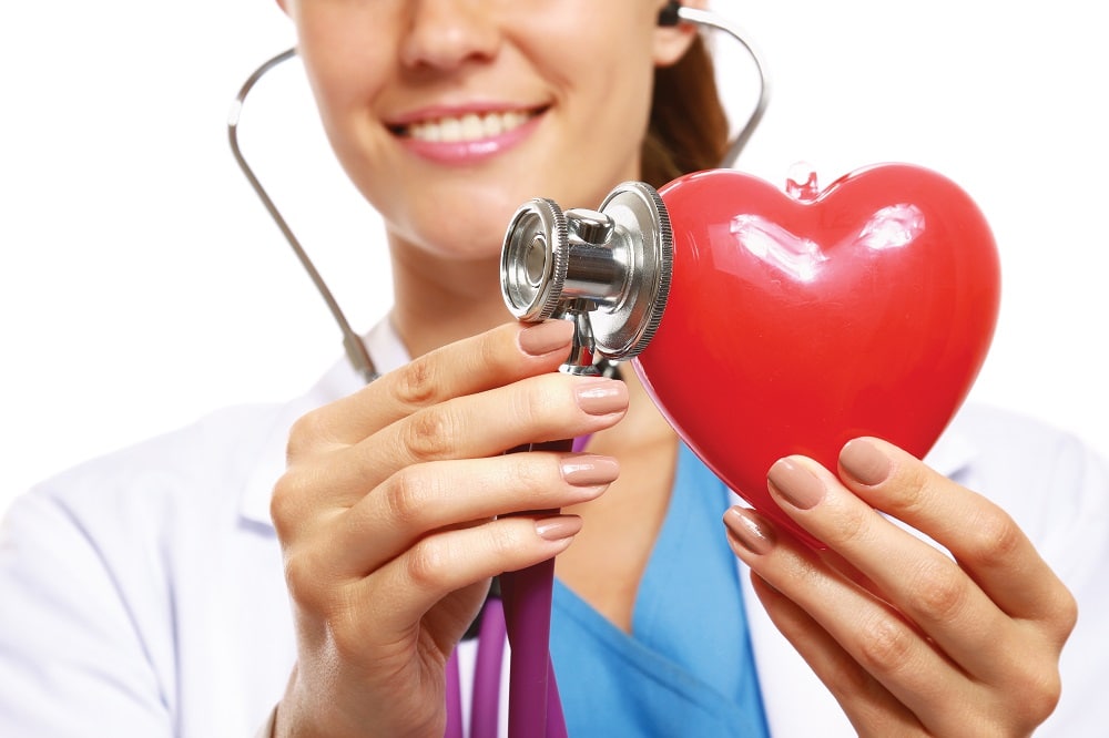 A,Doctor,With,Stethoscope,Examining,Red,Heart,,Isolated,On,White